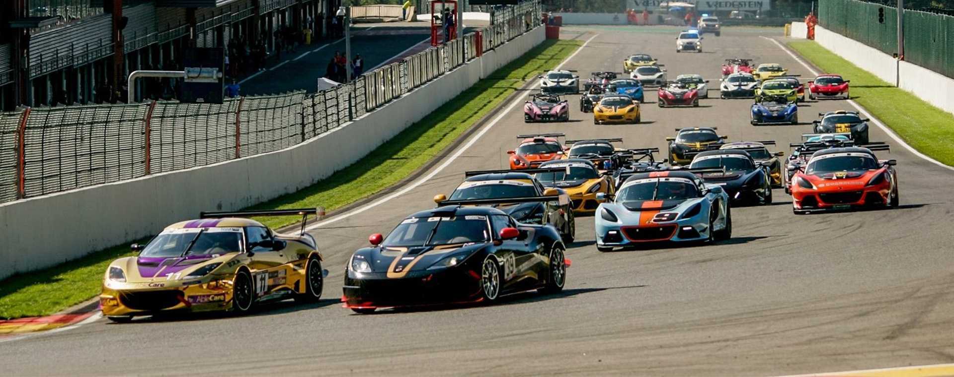 Sports cars race around a circuit.